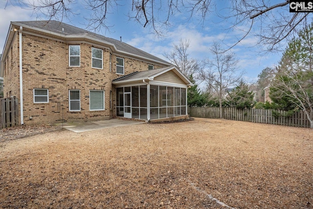 rear view of property featuring a sunroom and a patio area