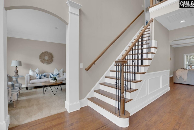 stairway featuring hardwood / wood-style flooring and ornate columns