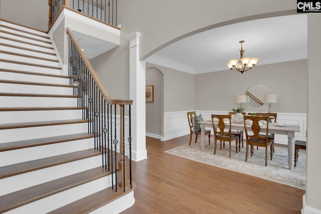 dining space featuring ornamental molding, hardwood / wood-style floors, and an inviting chandelier