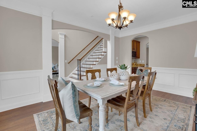 dining area featuring an inviting chandelier, crown molding, and wood-type flooring