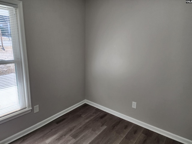 spare room with a healthy amount of sunlight and dark wood-type flooring