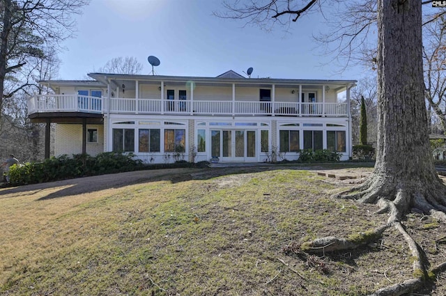 back of property with french doors and a lawn