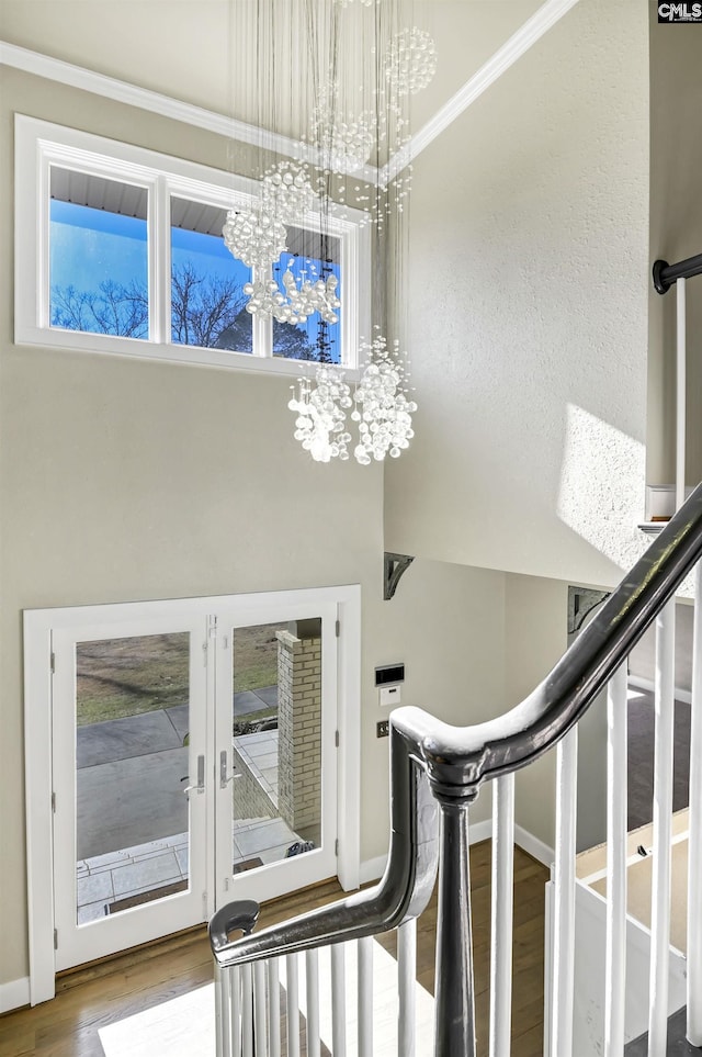 interior space with hardwood / wood-style floors, french doors, and a chandelier