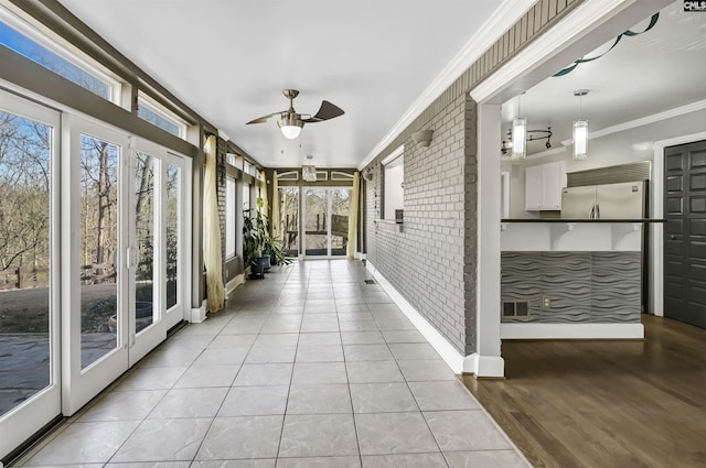 unfurnished sunroom with ceiling fan