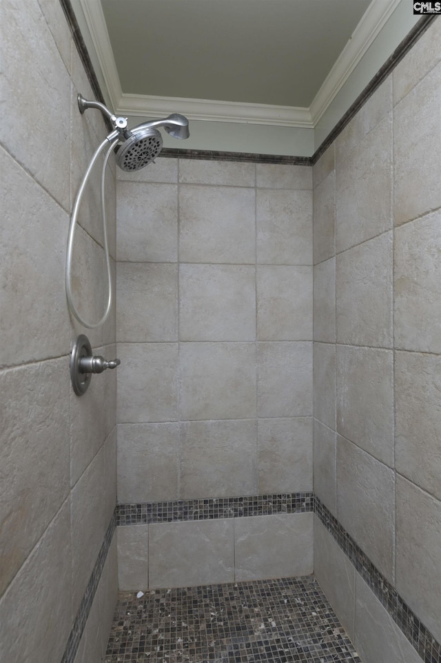 bathroom featuring crown molding and tiled shower