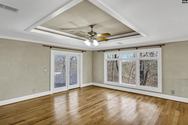 spare room featuring a tray ceiling, ornamental molding, and hardwood / wood-style flooring