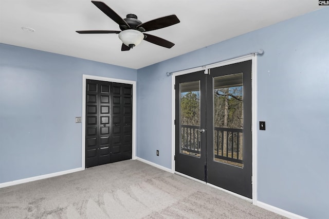 entryway with french doors, ceiling fan, and light carpet