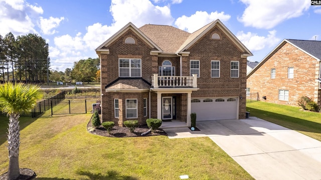 view of front of house featuring a garage, a balcony, and a front yard