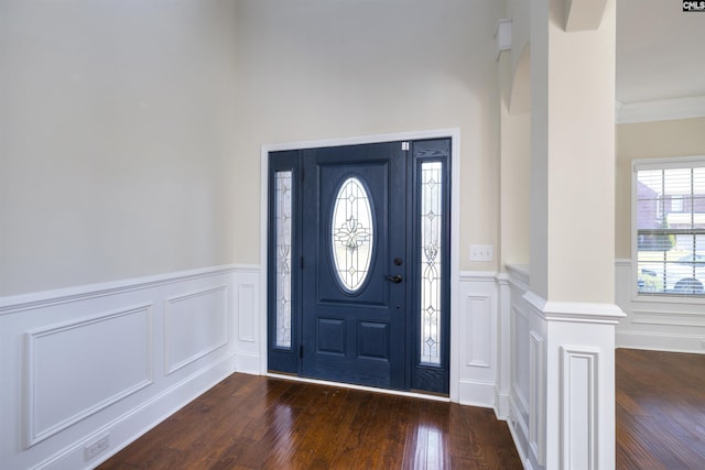 foyer entrance with ornamental molding and dark hardwood / wood-style flooring