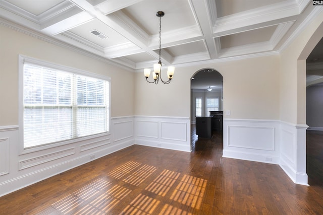 empty room featuring coffered ceiling, dark hardwood / wood-style floors, a chandelier, and beam ceiling