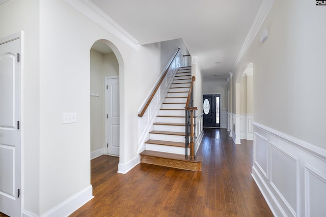 stairway with wood-type flooring and ornamental molding