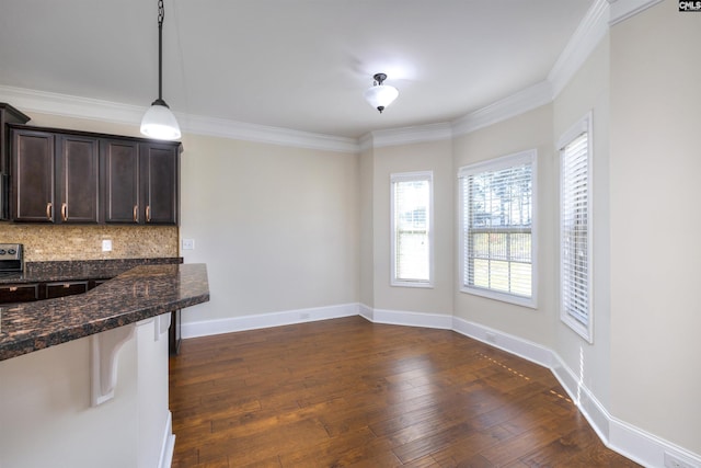 kitchen featuring crown molding, pendant lighting, dark hardwood / wood-style flooring, and dark stone counters