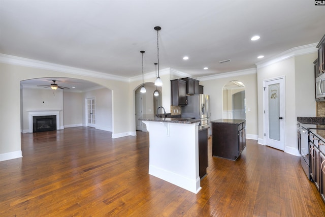 kitchen featuring stainless steel appliances, hanging light fixtures, dark hardwood / wood-style floors, and dark brown cabinetry