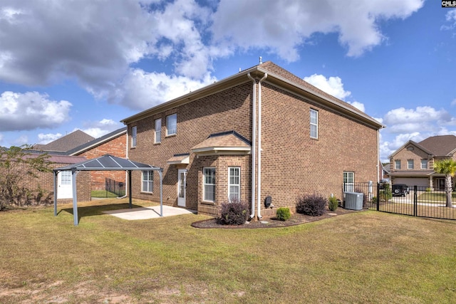 back of property featuring a gazebo, a patio, central AC unit, and a lawn