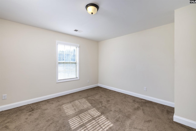 spare room with dark colored carpet