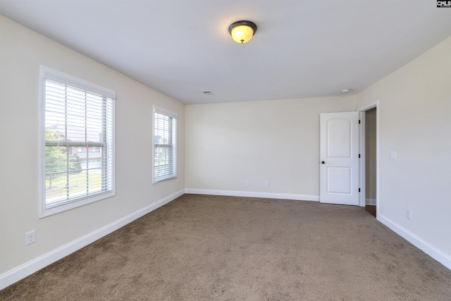 spare room with dark colored carpet