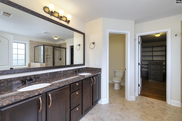 bathroom with walk in shower, tile patterned floors, toilet, and vanity