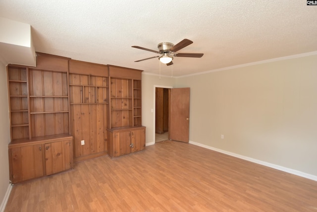 unfurnished living room featuring ornamental molding, light hardwood / wood-style floors, and a textured ceiling