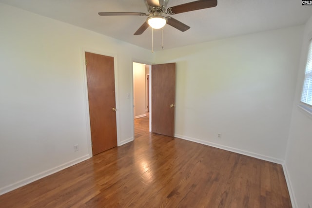 spare room with dark hardwood / wood-style flooring and ceiling fan