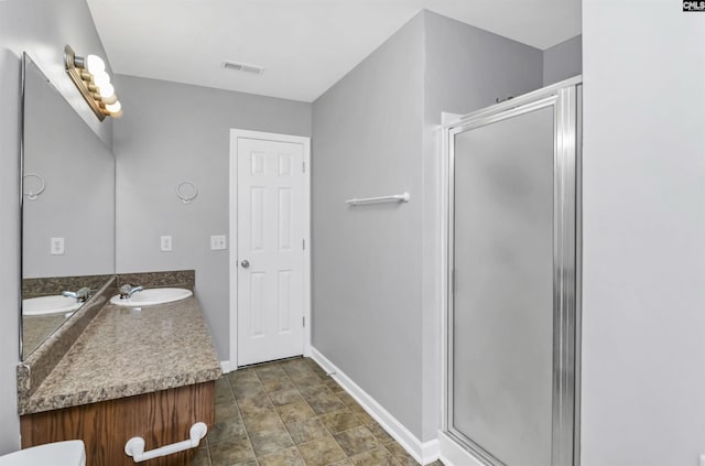 bathroom featuring vanity and a shower with door