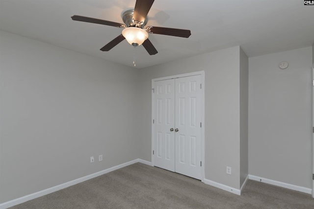 unfurnished bedroom featuring ceiling fan, light colored carpet, and a closet