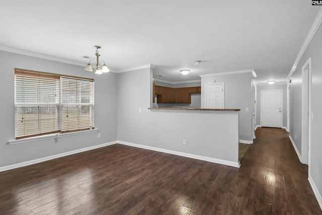 interior space with crown molding, dark wood-type flooring, a chandelier, and kitchen peninsula