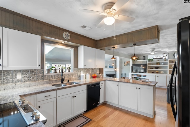 kitchen featuring pendant lighting, sink, black appliances, white cabinets, and kitchen peninsula