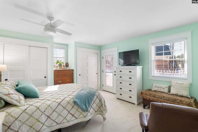 carpeted bedroom featuring multiple windows, two closets, and ceiling fan