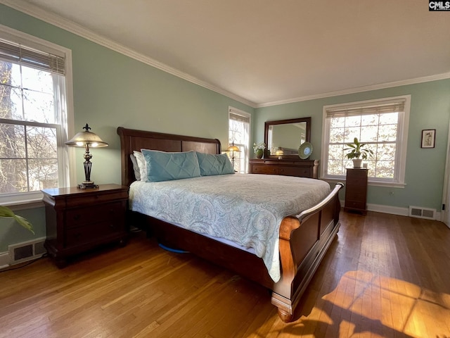 bedroom featuring hardwood / wood-style flooring, crown molding, and multiple windows