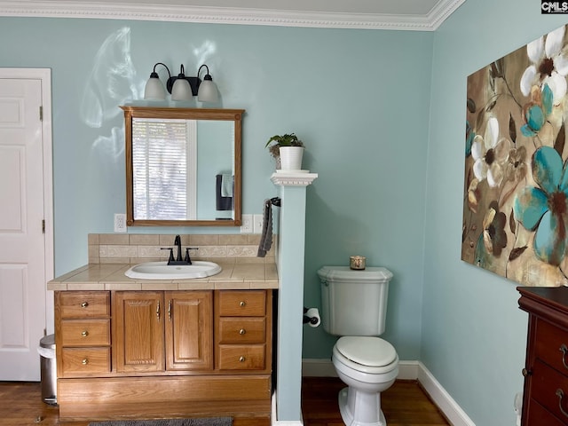 bathroom with vanity, wood-type flooring, crown molding, and toilet