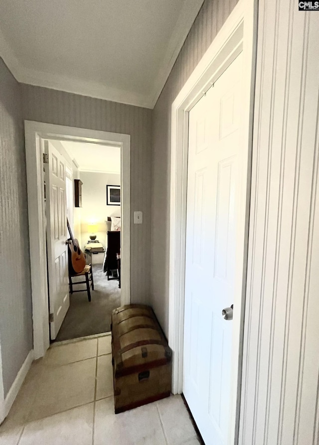 hall with ornamental molding and light tile patterned floors