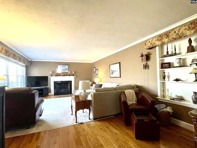 living room with crown molding, wood-type flooring, and built in features