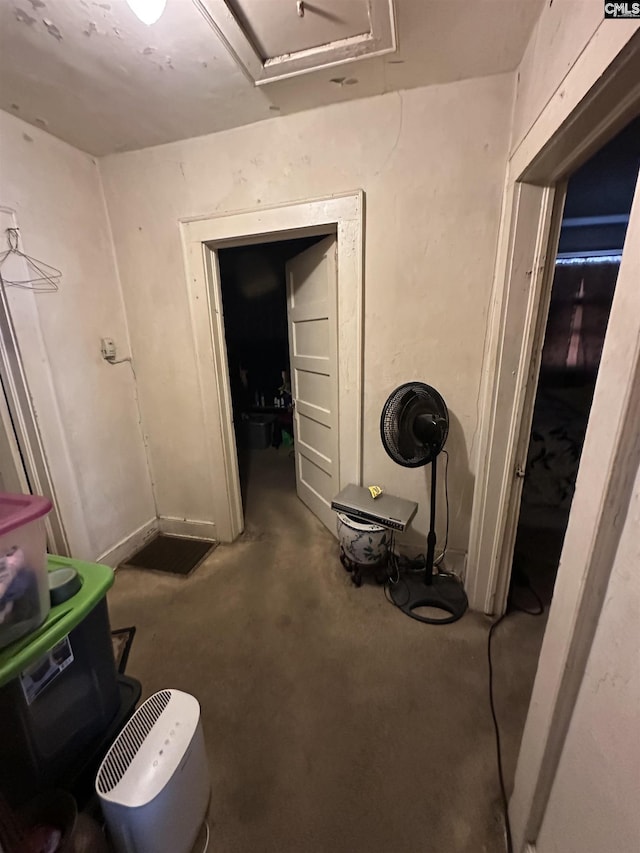 miscellaneous room with attic access and concrete floors