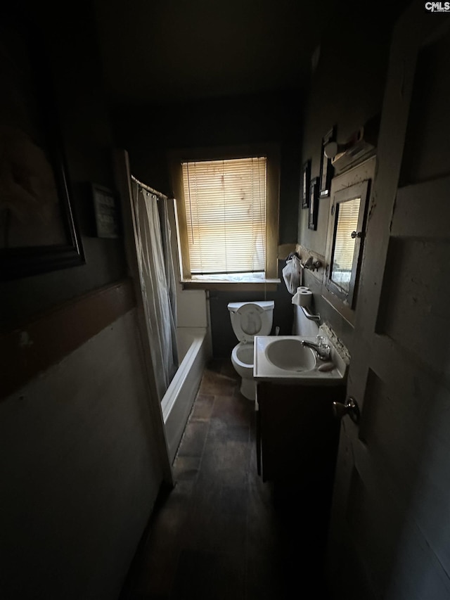 bathroom featuring a healthy amount of sunlight, vanity, toilet, and shower / bath combo with shower curtain