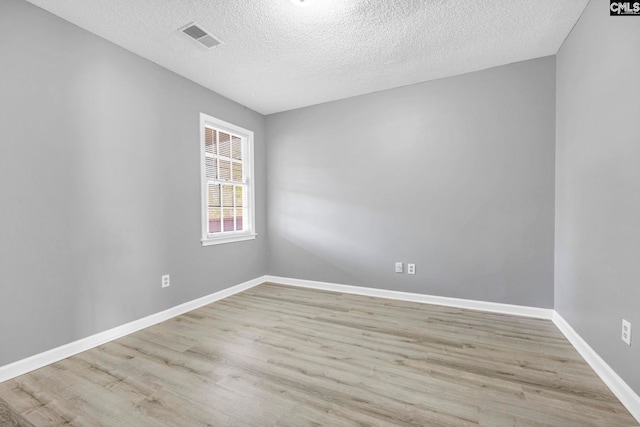 unfurnished room featuring light hardwood / wood-style floors and a textured ceiling