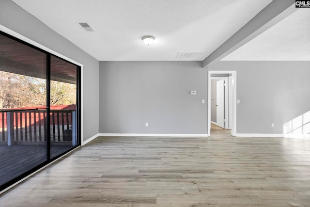 empty room featuring light hardwood / wood-style flooring and a textured ceiling