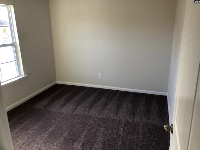 unfurnished room featuring dark colored carpet