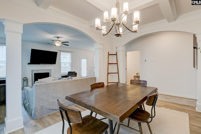 dining area featuring ceiling fan, beam ceiling, decorative columns, a high end fireplace, and light hardwood / wood-style floors