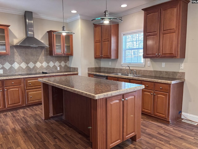 kitchen with wall chimney exhaust hood, glass insert cabinets, a center island, hanging light fixtures, and black electric stovetop