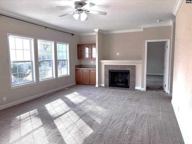 unfurnished living room with light carpet, ornamental molding, a tile fireplace, and baseboards