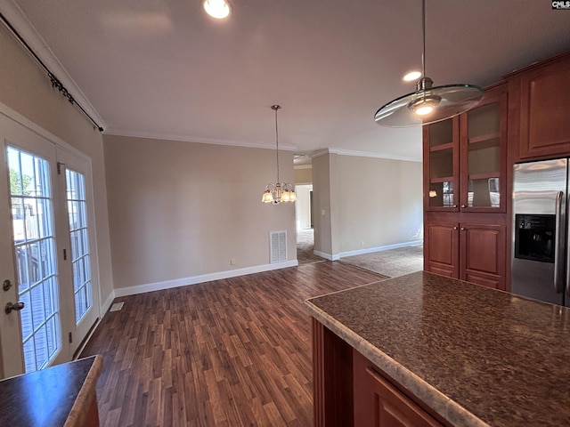 kitchen featuring stainless steel refrigerator with ice dispenser, dark countertops, visible vents, ornamental molding, and dark wood-type flooring