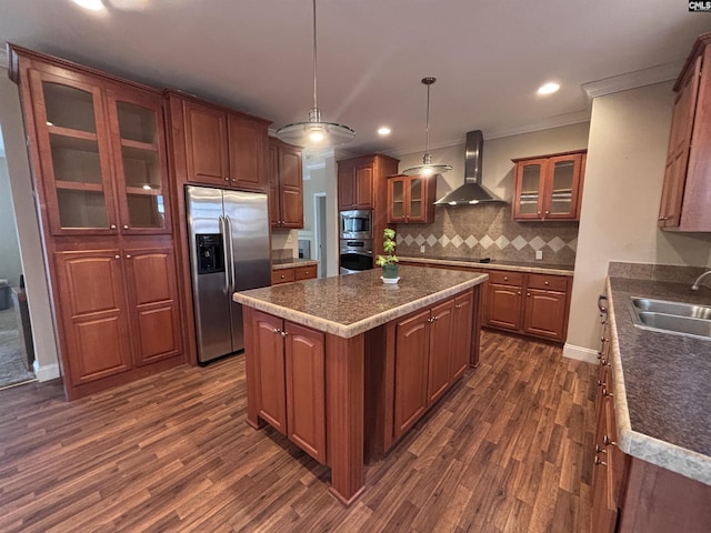 kitchen with stainless steel appliances, a sink, a kitchen island, wall chimney exhaust hood, and glass insert cabinets