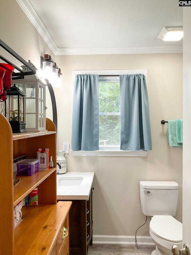 bathroom featuring vanity, hardwood / wood-style floors, ornamental molding, and toilet