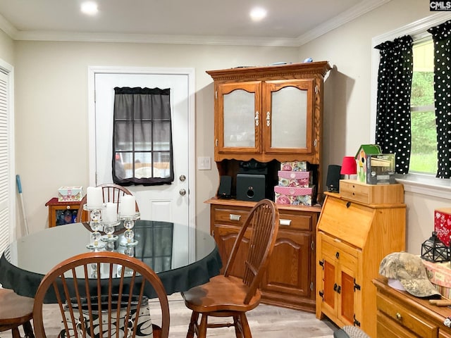 dining room with ornamental molding and light hardwood / wood-style floors