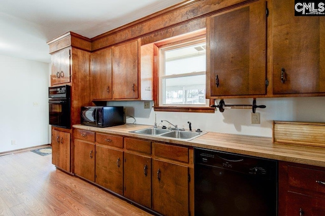 kitchen with sink, light hardwood / wood-style flooring, and black appliances