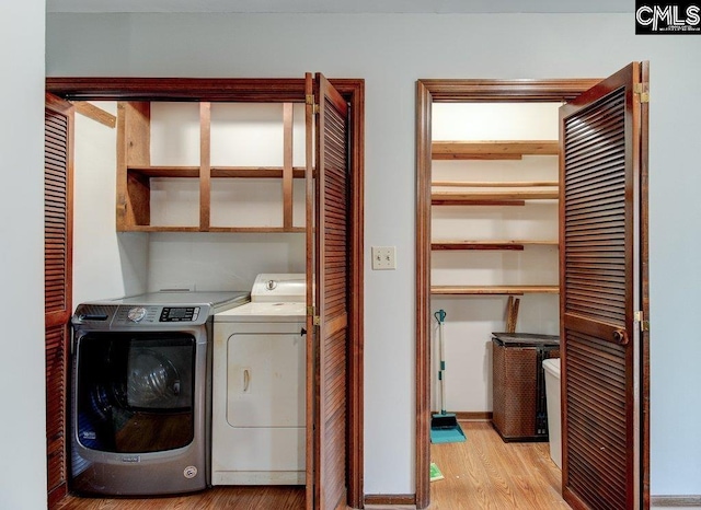 clothes washing area featuring washing machine and dryer and light hardwood / wood-style flooring