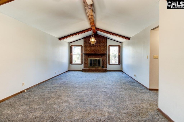 unfurnished living room with plenty of natural light, lofted ceiling with beams, a brick fireplace, and carpet