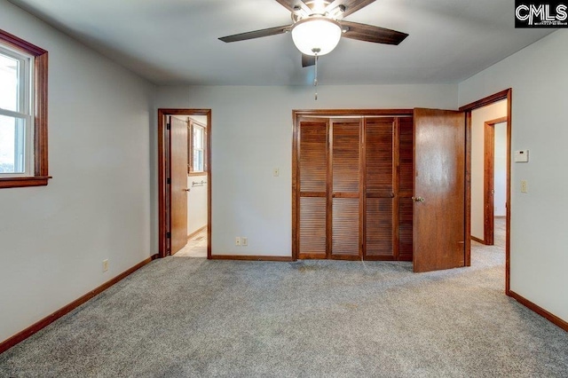 unfurnished bedroom with light colored carpet, a closet, and ceiling fan