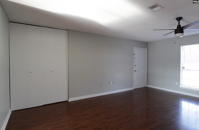 spare room with a textured ceiling, dark hardwood / wood-style floors, and ceiling fan