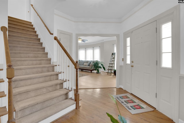 foyer featuring crown molding, wood-type flooring, and ceiling fan